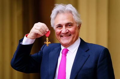English broadcaster John Suchet poses with a medal after being appointed an Officer of the Order of the British Empire following an investiture ceremony at Buckingham Palace in central London. AFP