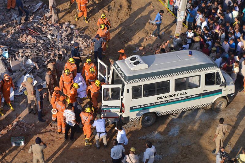 Members of the National Disaster Response Force (NDRF) remove a victim from the rubble. AFP