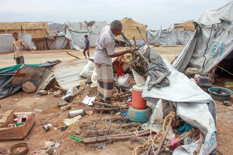 A Yemeni man rebuilds his tent after it was destroyed by torrential rain in a makeshift camp for the displaced in the northern Hajjah province, on April 19, 2020. / AFP / ESSA AHMED
