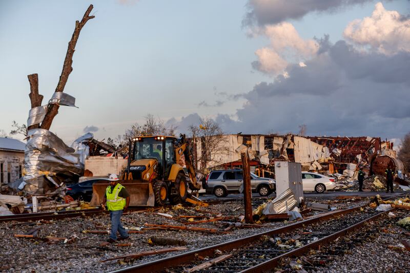 Workers remove debris blocking railroad tracks in Selma. AP