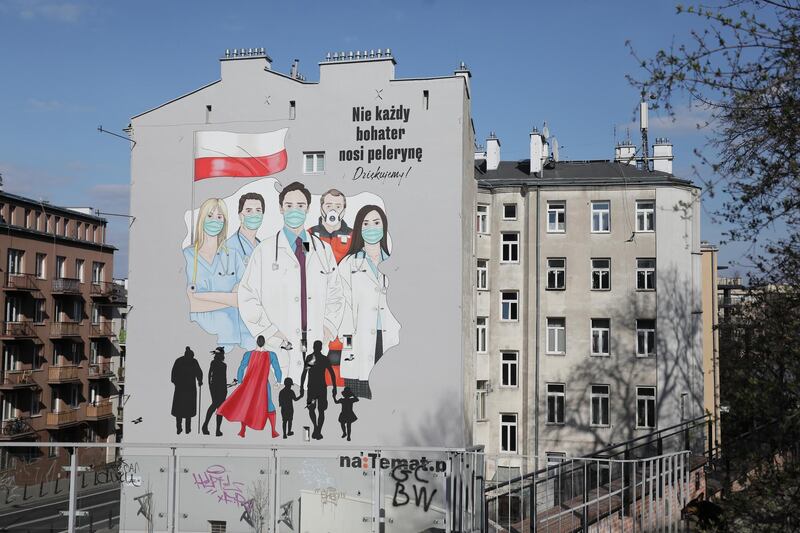 A mural showing medical personnel wearing protective masks is painted on a wall of a building in Warsaw, Poland. Reuters