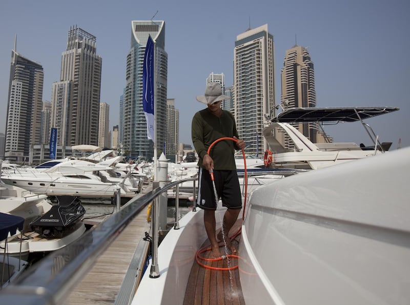 August 27, 2011 - Ronald from the Philippines hoses down a San Lorenzo 62 yacht in Dubai Marina. Ronald says he washes the boat almost everyday which is for sale for 8million Dhs by a Russian owner. Ronald says he enjoys the freedom his job gives him and enjoys the time he can spend out on the sea at times. Pawel Dwulit 
