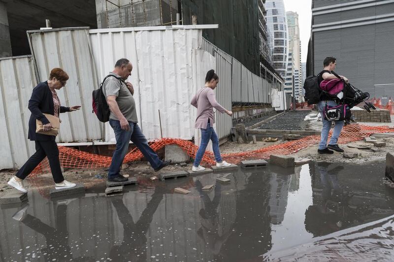 Residents of Barsha Heights navigate a flooded street. Antonie Robertson / The National