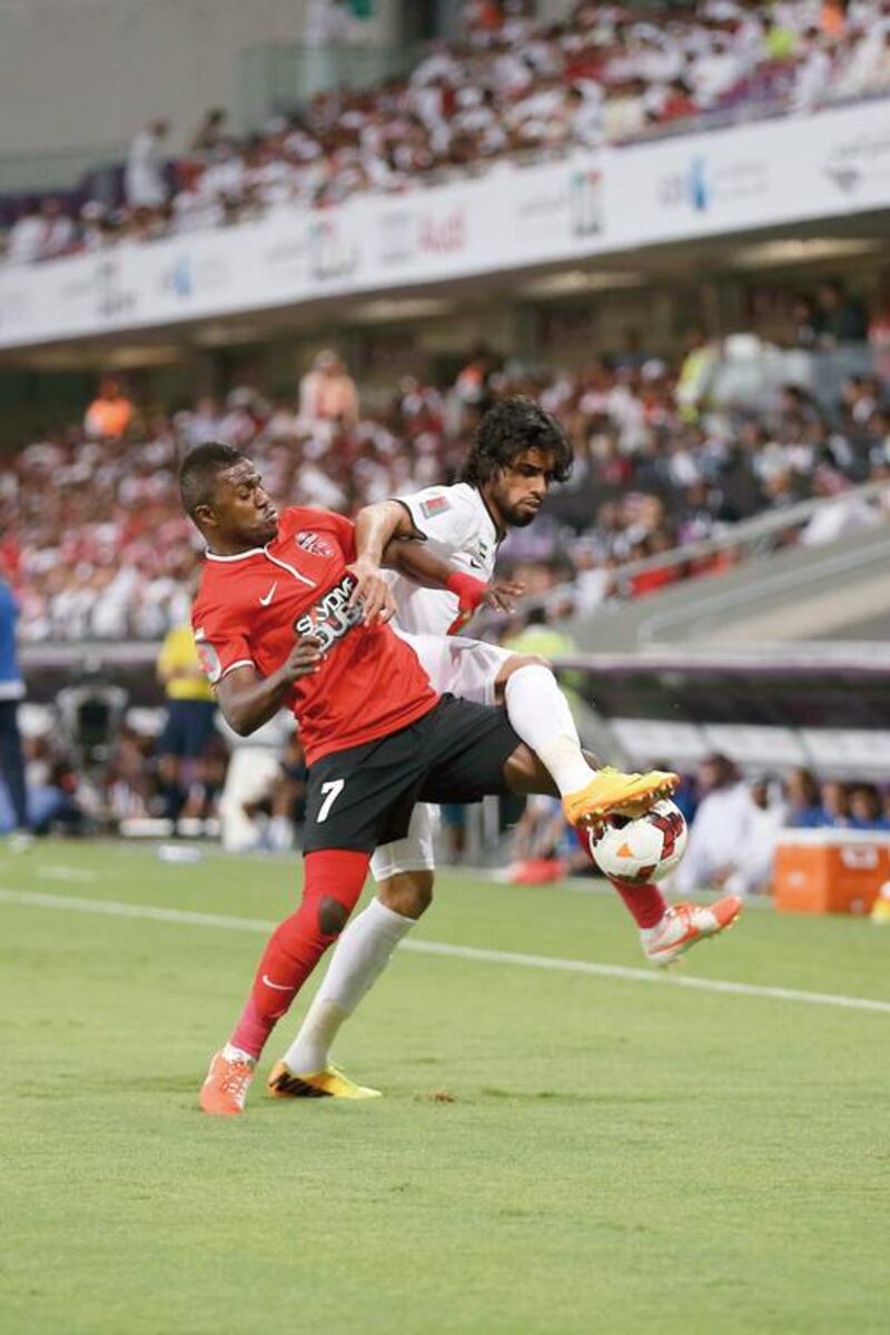 Al Ahli's Ismail Al Hammadi, left, battles for the ball during the Arabian Gulf Cup final between against Al Jazira at Hazza bin Zayed Stadium on April 19, 2014. Al Hammadi hit the game-winner in the 81st minute for Ahli. Al Ittihad