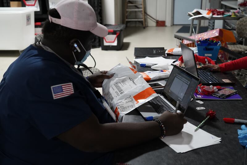 A worker at Mako Medical Laboratories registers a FedEx package full of PCR tests. Willy Lowry / The National