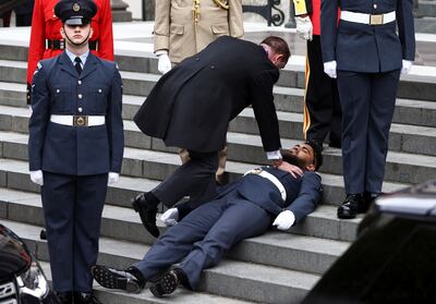 A guardsman faints on the steps of St Paul's Cathedral in warm, sunny weather in London. Getty Images