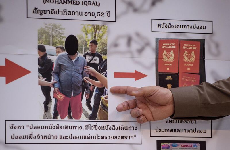 Commander of the Immigration Bureau, Lt. Gen. Suttipong Vongpint (hand at R), points to a board with information about an apprehended passport forger during a press conference in Bangkok on January 19, 2018.
A Pakistani passport forger whose fakes may have been sold to Islamic State operatives has been arrested in Thailand, police said on January 19, ending a career that helped people slip into Europe illegally. / AFP PHOTO / Roberto SCHMIDT