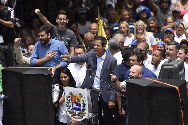 Juan Guaido, president of the National Assembly who swore himself in as the leader of Venezuela, center, sings the national anthem with attendees during a rally in Los Teques, Miranda state, Venezuela, on Saturday, March 30, 2019. With three blackouts in less than a month and Caracas bracing for power rationing, Guaido has called on residents of poorer areas south of the capital to protest the regime's rules as the outages have virtually shut down the country. Photographer: Carlos Becerra/Bloomberg