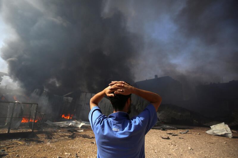 A man watches a  factory in the northern Gaza Strip burn after it was hit by what witnesses said was an Israeli artillery bombardment. Reuters