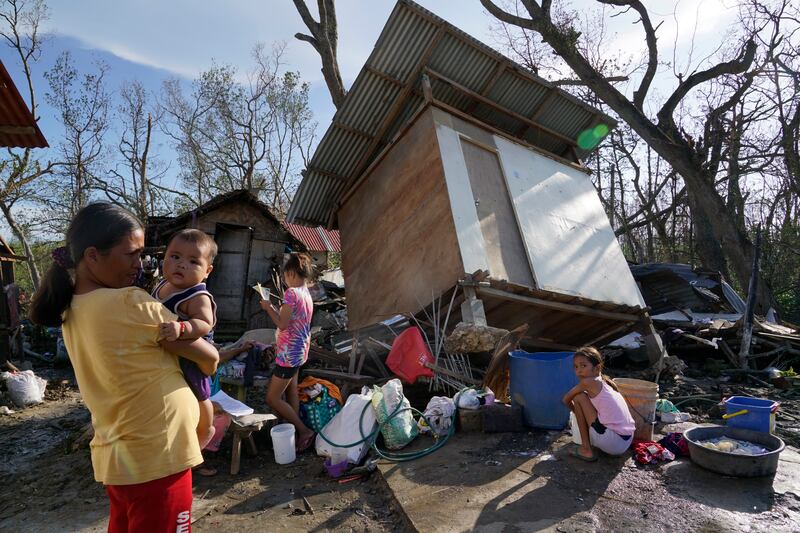 Residents stand amid damaged homes following Typhoon Rai in Talisay, Cebu province, central Philippines. AP Photo