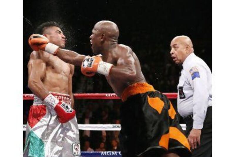 Floyd Mayweather Jr lands a controversial knockout punch to Victor Ortiz as referee Joe Cortez, right, watched on during their WBC Welterweight bout in Las Vegas. John Locher / AP Photo