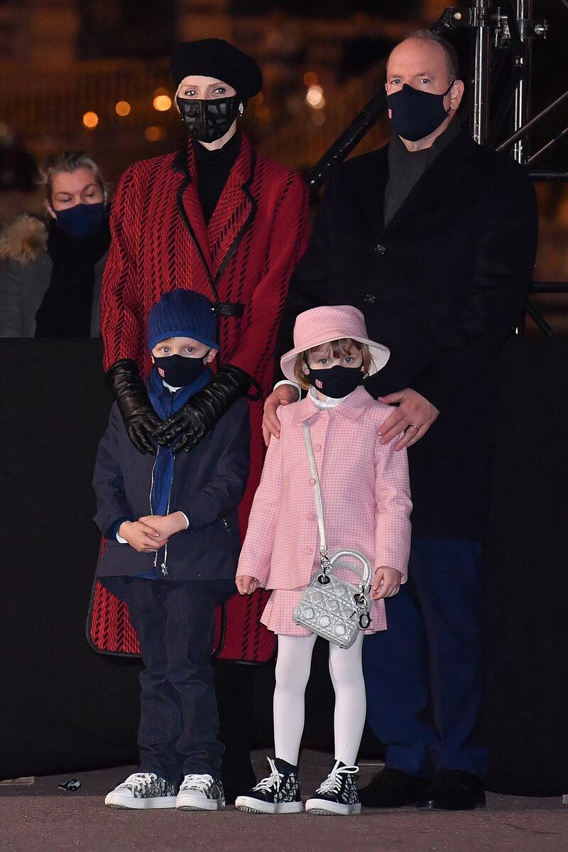 Princess Charlene, in a red and black coat, with Prince Albert II of Monaco, Prince Jacques and Princess Gabriella attend the ceremony of Sainte-Devote on January 26, 2021 in Monaco. Getty Images