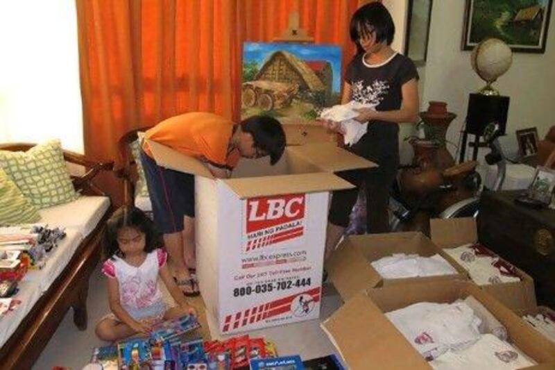 Daisy Dy-Liacco with her children Abigail, Isaiah and Danielle, sorting out donations for the Lapis, Papel, Aklat Atbp project, organised by the University of the Philippines alumni association in the UAE.