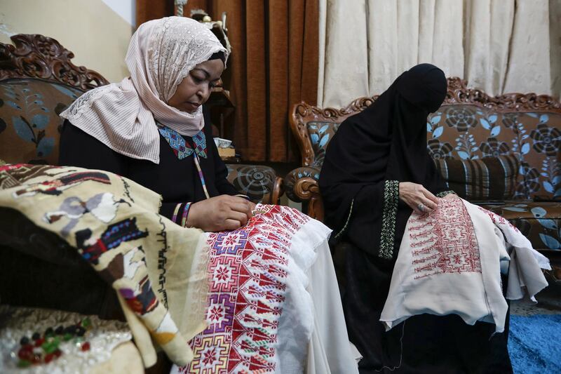 Um Zeid, 47 year-old, and Khawla 48 year-old, Palestinian refugees women living in Jordan embroider a traditional Palestinian dresses for customers at Al-Baqaa Palestinian refugee camp, near Amman, Jordan, June 16, 2020. Picture taken June 16, 2020. REUTERS/Muhammad Hamed