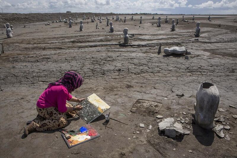 An artist, Novi, paints at the mudflow site during the anniversary of the eruption. Ulet Ifansasti / Getty Images