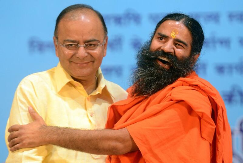 Indian yoga guru Baba Ramdev (R) greets Bharatiya Janata Party senior leader Arun Jaitley during Ramdev’s Pledge Completion rally in New Delhi, India. Raveendran / AFP