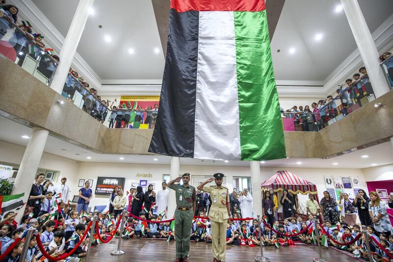 DUBAI, UNITED ARAB EMIRATES - Abdullah Ali Almansoori and Humaid Mohammed Alnuaimi saluting the flag with the students from Gems Royal Dubai School celebrating UAE flag day.  Leslie Pableo for The National fro Anam Rizvi’s story