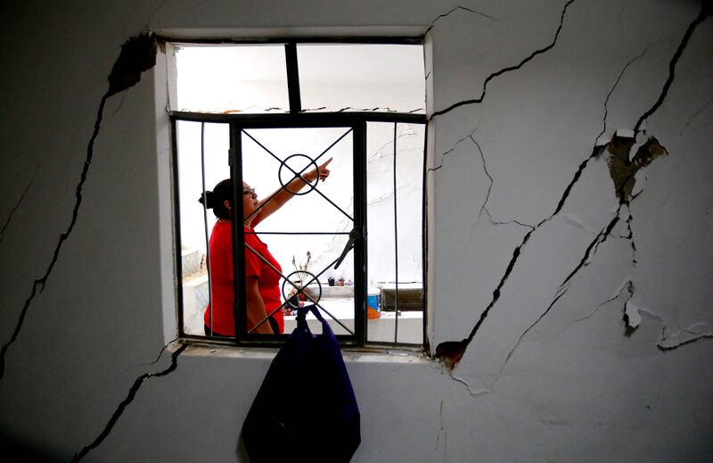 A woman surveys damage to her home, rendered uninhabitable after an earthquake caused by a geological fault that runs through the Santa Rosa neighbourhood of Ciudad Guzman, Mexico. AFP