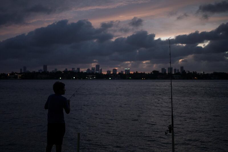 The Miami skyline is seen in the background as a boy fishes ahead of the arrival of Hurricane Irma in Miami Beach, Florida. Adrees Latif / Reuters