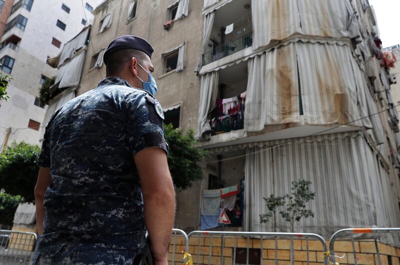 A Lebanese policeman is deployed to enforce isolation outside a building where dozens of foreign workers living in overcrowded apartments have tested positive with the coronavirus, in Beirut, Lebanon. AP Photo