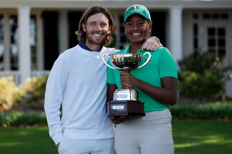 Maya Gaudin poses for photos with the trophy and Tommy Fleetwood after winning the Drive, Chip and Putt tournament. EPA