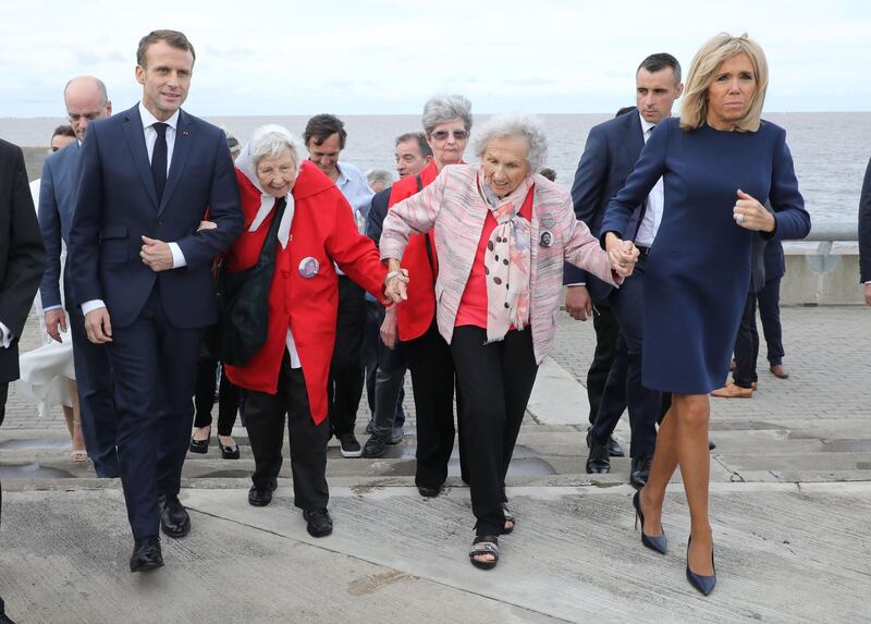 France's President Emmanuel Macron wife Brigitte walk with human rights activists during a visit to the Remembrance Park --a monument on the banks of the Rio de la Plata- in memory of the 30,000 people who disappeared or were killed under the 1976-1983 military regime. AFP