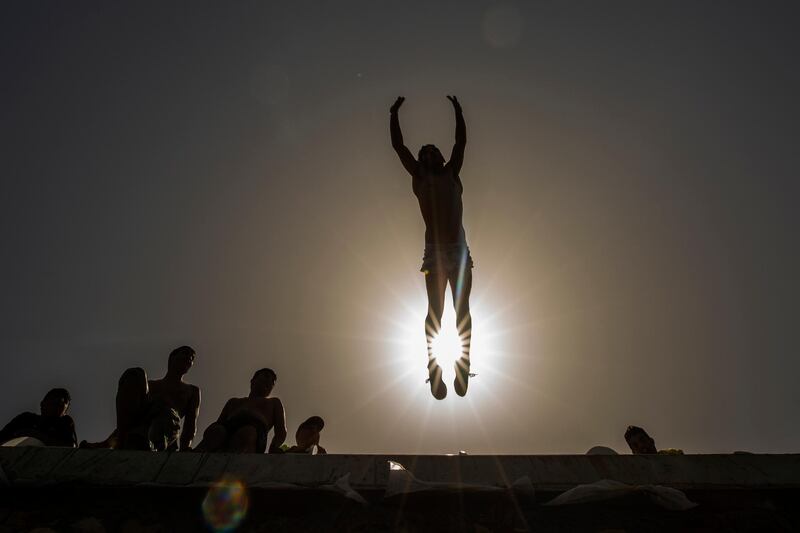 A youth jumps into the Mediterranean off the Saida Corniche during lockdown over Orthodox Easter to curb the spread of coronavirus in Saida, Lebanon. AP Photo