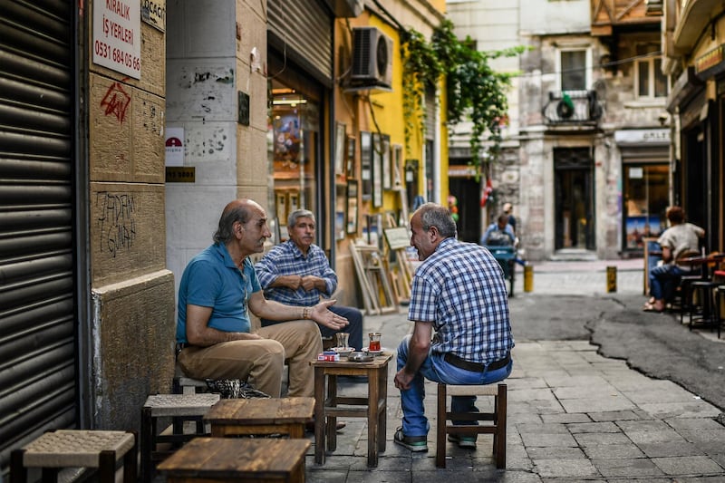 Men chat as they drink tea on June 22, 2018 in Istanbul. - Turkey is preparing for tight presidential and parliamentary elections due on June 24, while many analysts say President Erdogan wants a major foreign policy success to give him a final boost. (Photo by Aris MESSINIS / AFP)