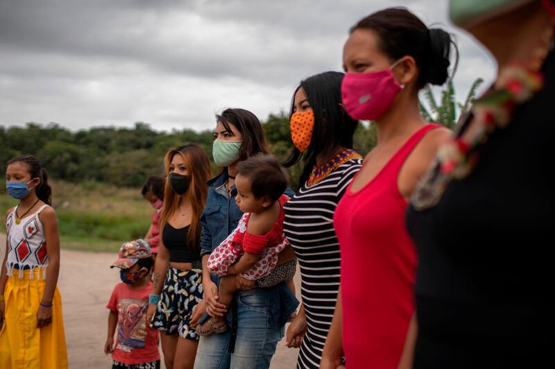 Indigenous Guarani women and children listen to music being played at the Sao Mata Verde Bonita tribe camp, in Guarani indigenous land, in Marica, Rio de Janeiro state, Brazil.  AFP