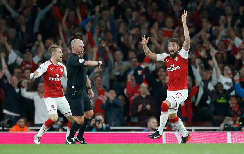 Arsenal's Olivier Giroud reacts as and celebrates as referee Mike Dean, centre, says the ball has crossed the line for a goal during their English Premier League soccer match between Arsenal and Leicester City at the Emirates stadium in London, Friday, Aug. 11, 2017. (AP Photo/Alastair Grant)