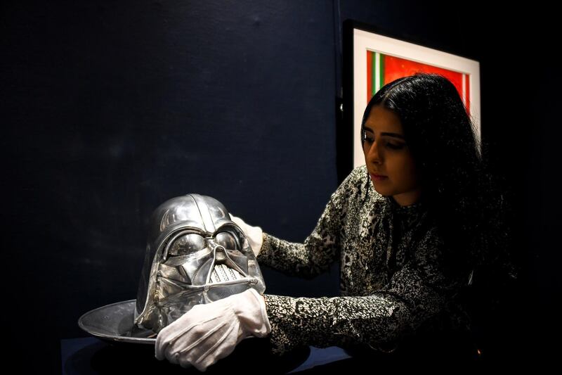 A Sotheby's employee holds a Head of Card Vader of 1999 as part of the Star Wars auction in London. Sotheby's will now host its second sale dedicated to 'Star Wars' collectibles, titled 'Star Wars Online'. AP Photo