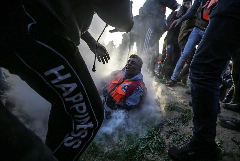 A Palestinian paramedic cries in pain after apparently being injured by an Israeli tear gas grenade during clahses that broke out after Friday protests near the border between Israel and the Gaza Strip, in East Gaza. EPA