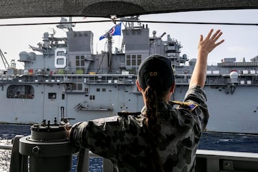 The Commanding Officer of HMAS Parramatta, Commander Anita Nemarich, waves at USS America during officer of the watch manoeuvres in the South China Sea, in this April 18, 2020 handout photo. Australia Department Of Defence/Handout via REUTERS ATTENTION EDITORS - THIS IMAGE HAS BEEN SUPPLIED BY A THIRD PARTY. NO RESALES. NO ARCHIVES. MANDATORY CREDIT MUST CREDIT AUSTRALIA DEPARTMENT OF DEFENCE