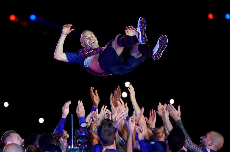 Barcelona's Andres Iniesta is thrown in the air by teammates during a tribute after the Spanish league football match between Barcelona and Real Sociedad at the Camp Nou stadium in Barcelona. Iniesta, who joined Barcelona's academy 22 years ago, played his final game for the club. Lluis Gene / AFP