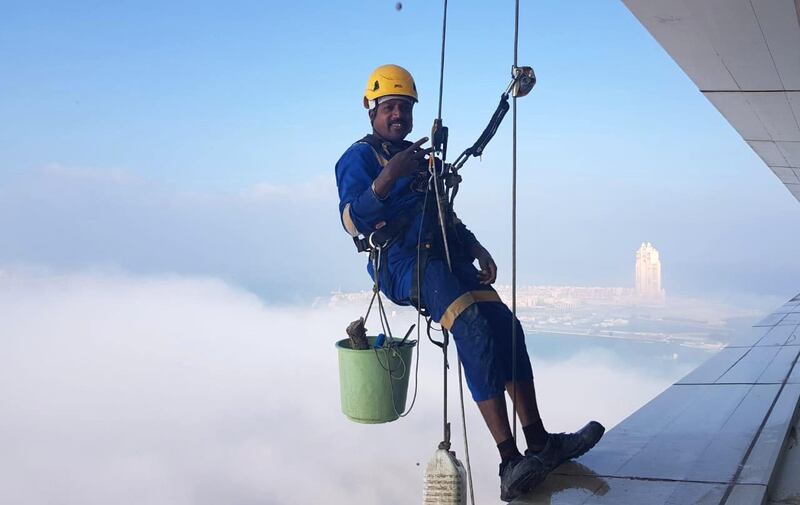 Window cleaners work on Al Ain Tower with view of Etihad Towers in the background in Al Khalidiyah, Abu Dhabi. Erica ElKhershi / The National  of Etihad Towers taken from Al Ain Tower in Al Khalidiyah, Abu Dhabi. Erica ElKhershi / The National