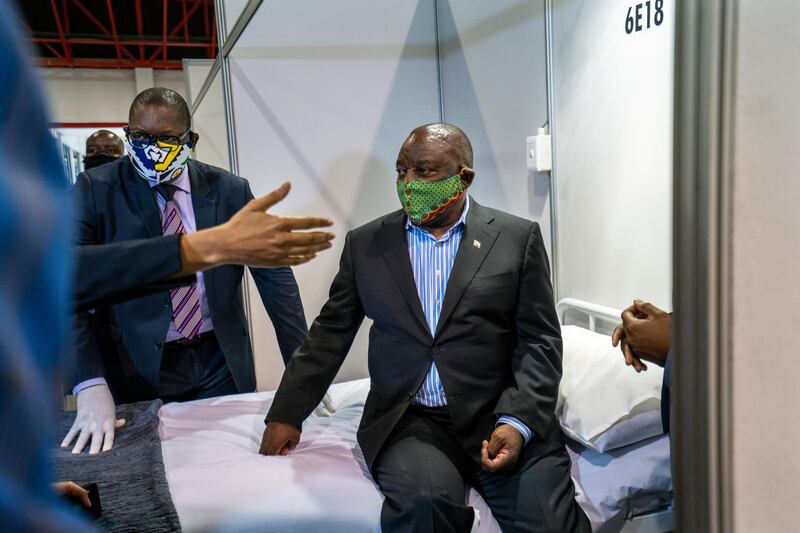 FILE- In this file photo taken Friday, April 24, 2020, South African President Cyril Ramaphosa visits the COVID-19 treatment facilities at the NASREC Expo Centre in Johannesburg, South Africa. South Africa is struggling to balance its fight against the coronavirus with its dire need to resume economic activity. The country with the Africaâ€™s most developed economy also has its highest number of infections â€” more than 19,000.  (AP Photo/Jerome Delay, File)