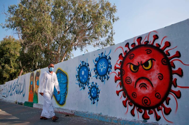 A Palestinian man walks past a coronavirus mural in Deir Al-Balah in the Gaza Strip.  AFP