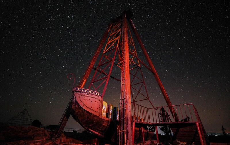 This long-exposure picture taken early shows a view of the Milky Way galaxy rising in the sky behind a children's ride above an abandoned amusement park near al-Nayrab, a village ravaged by pro-government forces bombardment, in Syria's northwestern Idlib province.  AFP