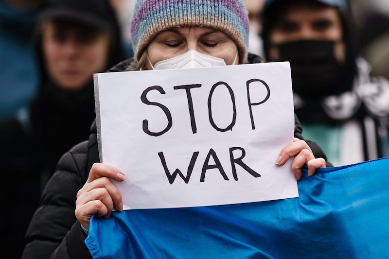 A woman holds a placard during a protest against Russia's military operation in Ukraine, in front of the Brandenburg Gate in Berlin, Germany. EPA