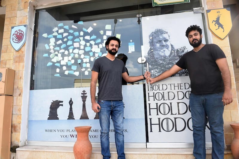 Owners Arsalan Sajid, right, and Hammad stand outside their Game Of Thrones-themed restaurant named King's Landing in Islamabad. Farooq Naeem / AFP