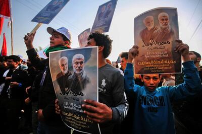 (FILES) In this file photo taken on January 01, 2021 Iraqi supporters of the Hashed al-Shaabi paramilitary carry portraits of  Iraqi commander Abu Mahdi al-Muhandis and Iranian Revolutionary Guards commander Qasem Soleimani during a demonstration in Baghdad's western Shoala neighbourhood, demanding the expulsion of US forces from Iraq  At least 17 pro-Iran fighters were killed in US strikes in Syria at the Iraq border overnight, the Syrian Observatory for Human Rights said on February 26, 2021. "The strikes destroyed three lorries carrying munitions... There were many casualties. Preliminary indications are that at least 17 fighters were killed, all members of Popular Mobilisation Forces," the director of the SOHR, Rami Abdul Rahman, told AFP, referencing the powerful coalition of pro-Iran Iraqi paramilitaries.
 / AFP / AHMAD AL-RUBAYE
