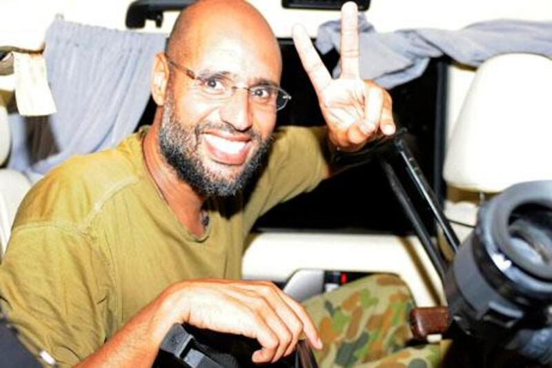 Saif al-Islam, the son of Libyan leader Muammar Gaddafi, gestures as he talks to reporters in Tripoli August 23, 2011. Saif told journalists that Libya, which has been largely overrun in the past 24 hours by rebel forces seeking to topple his father, was in fact in government hands and that Muammar Gaddafi was safe.  REUTERS/Paul Hackett (LIBYA - Tags: POLITICS CIVIL UNREST IMAGES OF THE DAY)