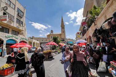 Palestinians shop at a market in the old city of Bethlehem in the occupied West Bank on September 14, 2021.  - The Palestinian economy is expected to grow four percent in 2021 after taking a battering in 2020 from the COVID-19 pandemic and a drop in foreign aid, with the economy in the West Bank and Gaza contracting by 11. 5 percent in 2020, the Palestine Monetary Authority reported mid-August.  (Photo by Emmanuel DUNAND  /  AFP)