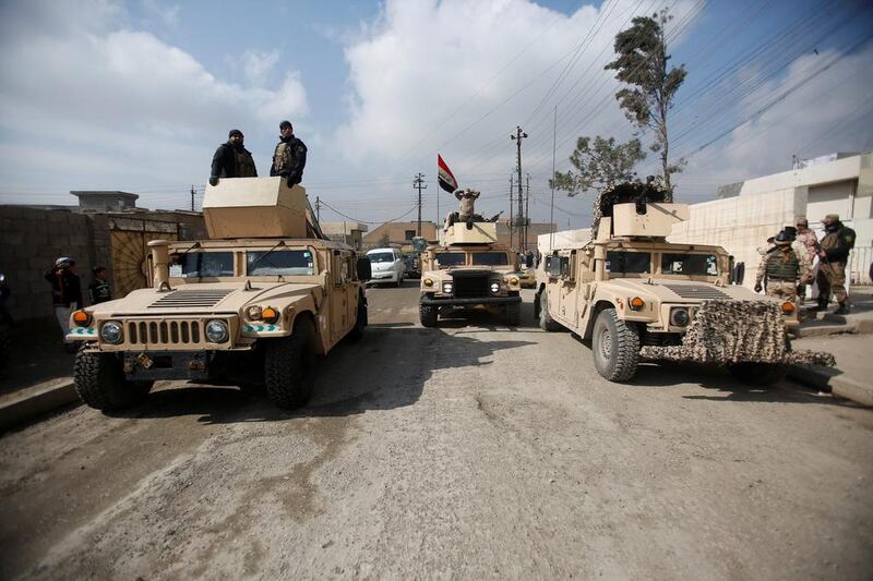 Iraqi army vehicles gather outside a building used by Iraqi security forces to check residents' ID cards in a search for Islamic State fighters in Mosul this week. Khalid Al Mousily / Reuters