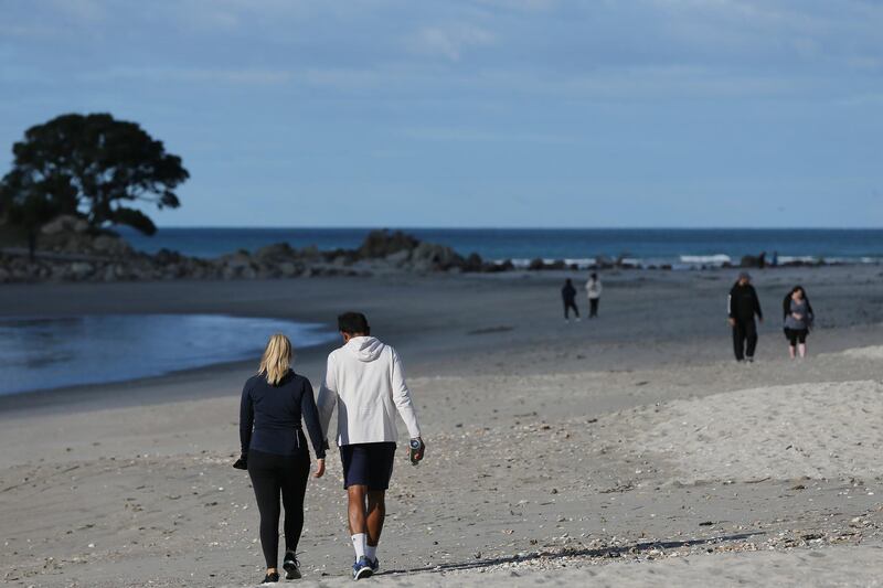 People walk on the beach in Cambridge, New Zealand. Getty Images