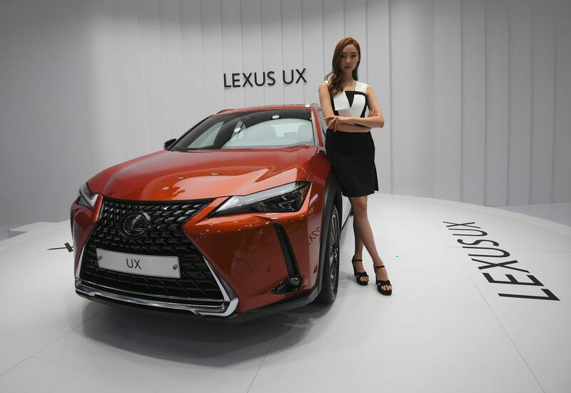 A model poses with a Lexus UX at the show. Jung Yeon-Je / AFP