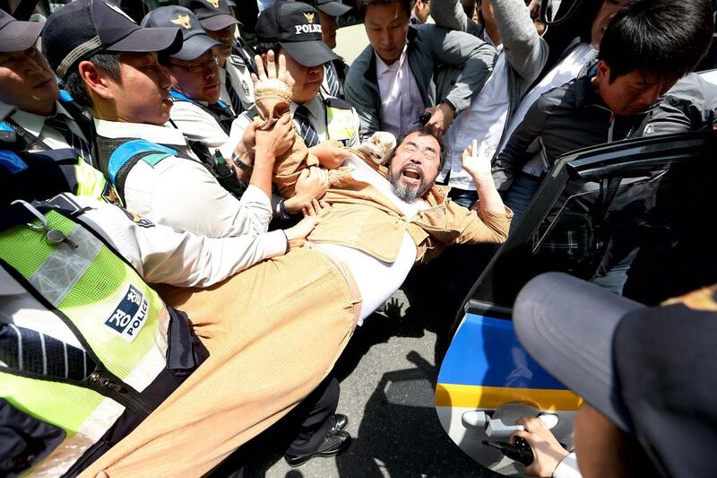 South Korean policemen detain a protester during a rally against the Japanese government in front of the Japanese Embassy in Seoul, South Korea. Jeon Heon-Kyun / EPA