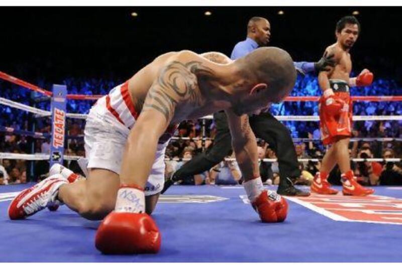 Referee Kenny Bayless directs Manny Pacquiao to his corner after knocking down Miguel Cotto in 2009 before beating him in the final round by TKO to take the WBO welterweight title. It is his seventh title in as many weight divisions.

MARK TERILL / AP