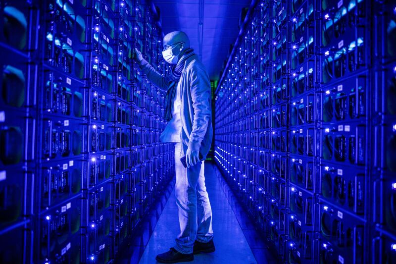 An employee inspects rigs mining Ethereum at a cryptocurrency farm in Romania. Concerns are mounting that an acceleration in NFT trading could be detrimental to environmental safety. Photo: Bloomberg