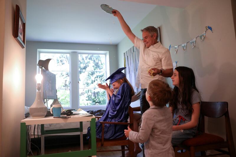 Doug Hassebroek pours confetti over his daughter Lydia, celebrating her graduation ceremony at their home during the outbreak of coronavirus disease in Brooklyn, New York, USA. Reuters